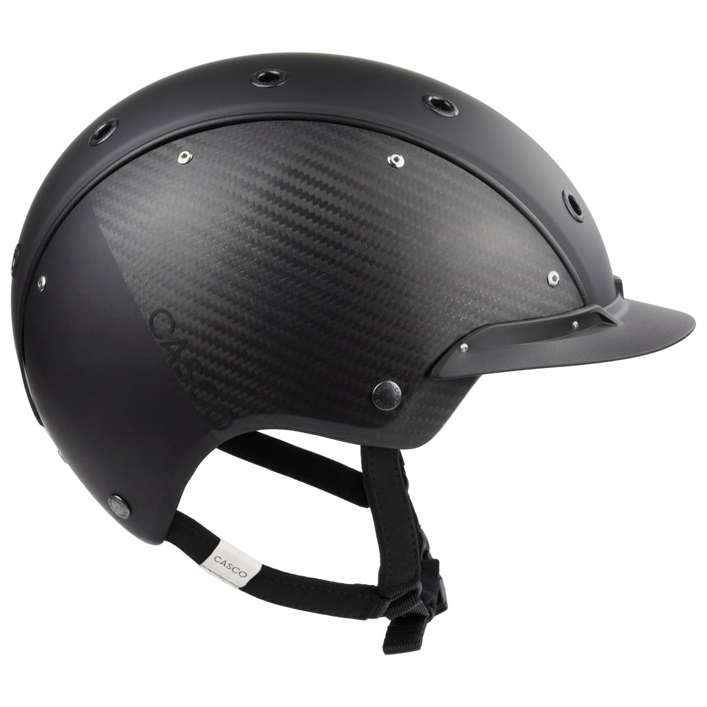 A mat black equestrian riding CASCO helmet made with mat carbon side panel, side view against white background 