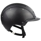 A mat black equestrian riding CASCO helmet made with mat carbon side panel, side view against white background 