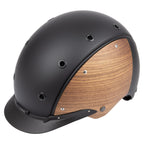 3/4 front view of A matte black equestrian riding Casco helmet with natural wood-look panels on the sides, featuring a black chin strap and a visible 'CASCO' brand  on the front  against white background