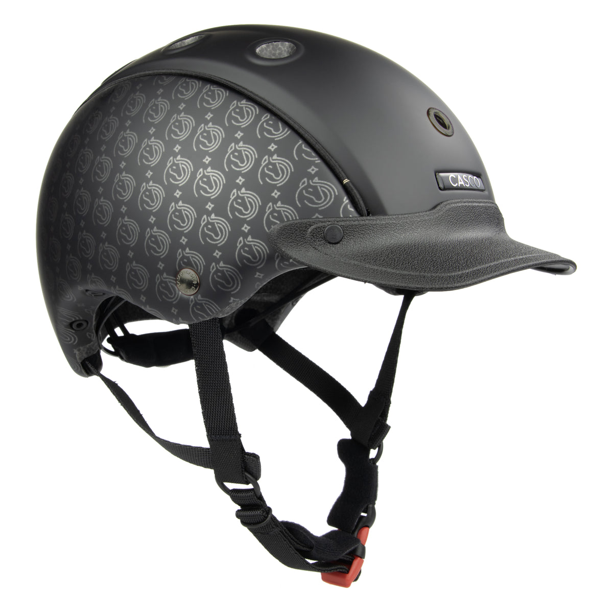 A CASCO matte black equestrian helmet with a subtle repeating logo pattern on the side panels, a matching black visor, and black chin straps with an orange release buckle, shown on a solid white background.