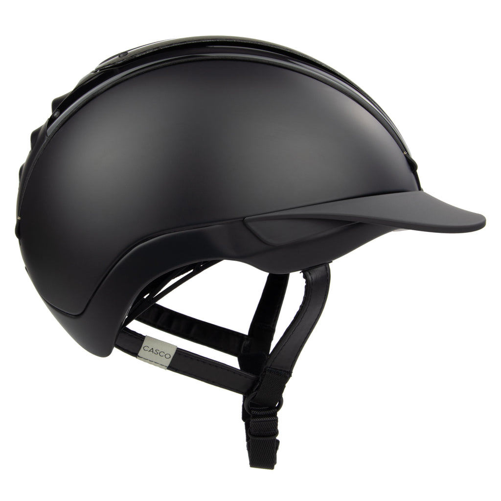 A black mat equestrian riding CASCO helmet with shiny top carbon parts, side view against white background