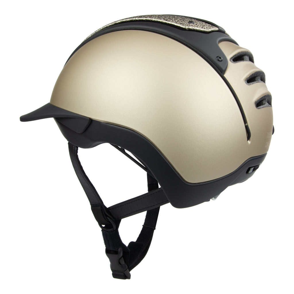 A 3/4 rear view of the equestrian riding Casco helmet,Champagne and black contrast finish with nubuck leather detailing, black strap 