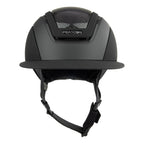 A matte black Casco equestrian helmet with a visor, black chin strap, and a textured carbon-fiber pattern on the top front, shown against a plain white background.