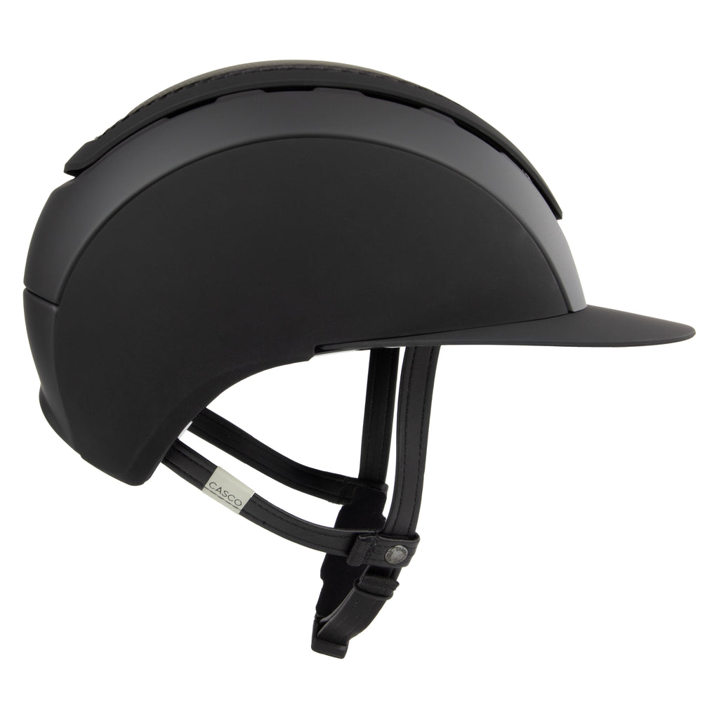 A matte black equestrian riding Casco helmet with a matching visor and black chin strap, shown from a three-quarters side profile on a white background.