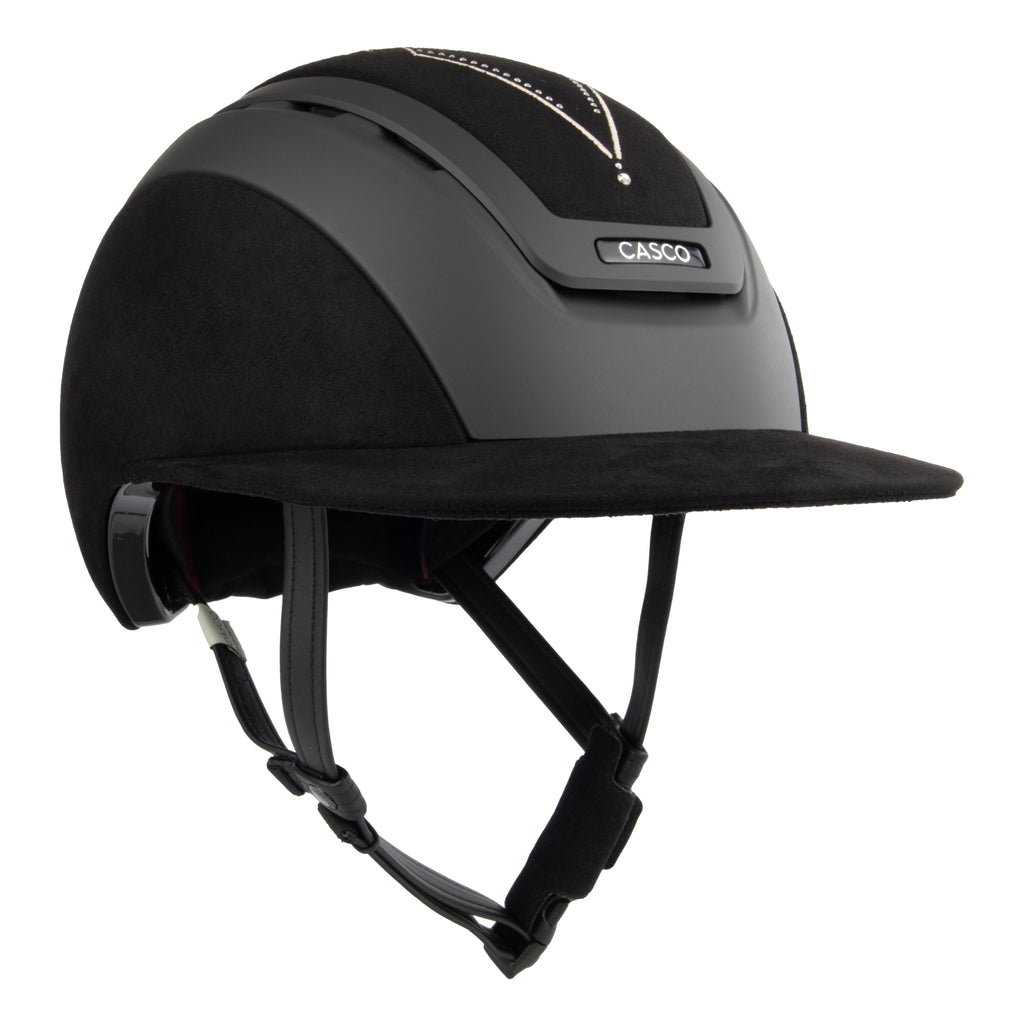 Front 3/4 view of A black Casco equestrian riding helmet with a matching visor, matte finish, brushed nubuck leather with Swarovski crystals and adjustable chin strap, shown on a solid white background.