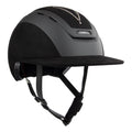 Front 3/4 view of A black Casco equestrian riding helmet with a matching visor, matte finish, brushed nubuck leather with Swarovski crystals and adjustable chin strap, shown on a solid white background.