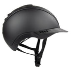 Matte black equestrian riding CASCO helmet with a visor and adjustable chin strap, shown from a side profile on a white background.