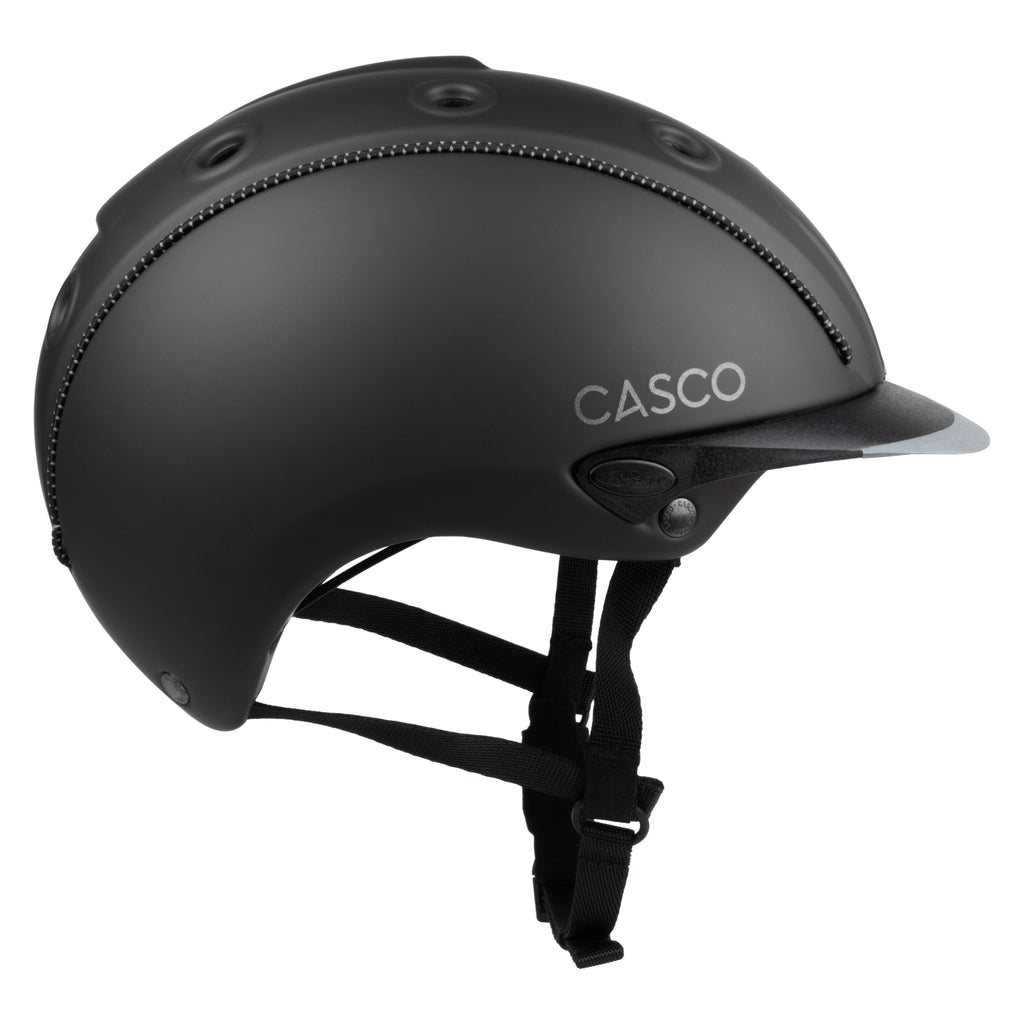 Matte black Casco equestrian helmet with a visor and black chin strap, shown from a side profile on a white background.