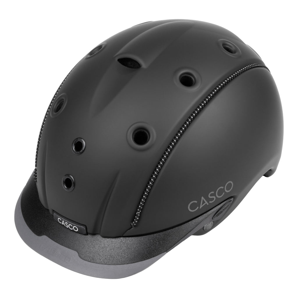 A matte black CASCO equestrian helmet with multiple ventilation holes, a chin guard, and a gray under-visor, shown on a solid white background.