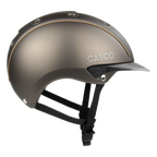 Side view A matte brown equestrian riding Casco helmet with a matching visor, black chin straps, and subtle tan stitching details, shown on a plain white background.