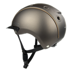 Side view A matte brown equestrian riding Casco helmet with a matching visor, black chin straps, and subtle tan stitching details, shown on a plain white background.