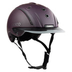 A matte dark purple Casco equestrian riding helmet with a matching visor and black chin straps, shown from a three-quarters angle on a white background.