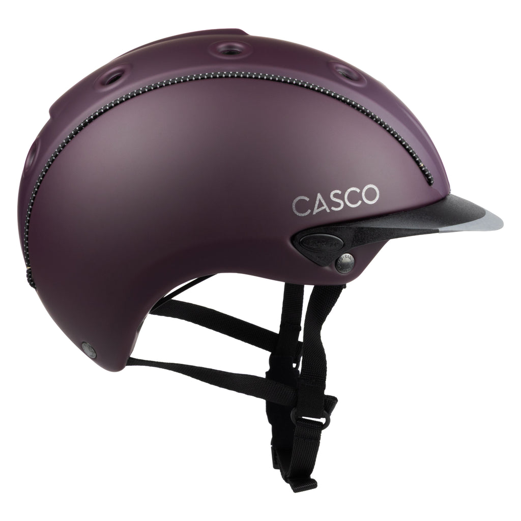 A matte dark purple Casco equestrian riding helmet with a matching visor and black chin straps, shown from a side view on a white background.