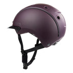 A matte dark purple Casco equestrian riding helmet with a matching visor and black chin straps, shown from a side view on a white background.