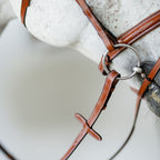 White horse wearing a Lumiere Milan convertible Havana leather snaffle bridle, closeup to the noseband