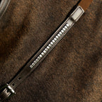 Close-up of a brown leather Lumiere Perseus breastplate with metal studs on a textured brown surface.