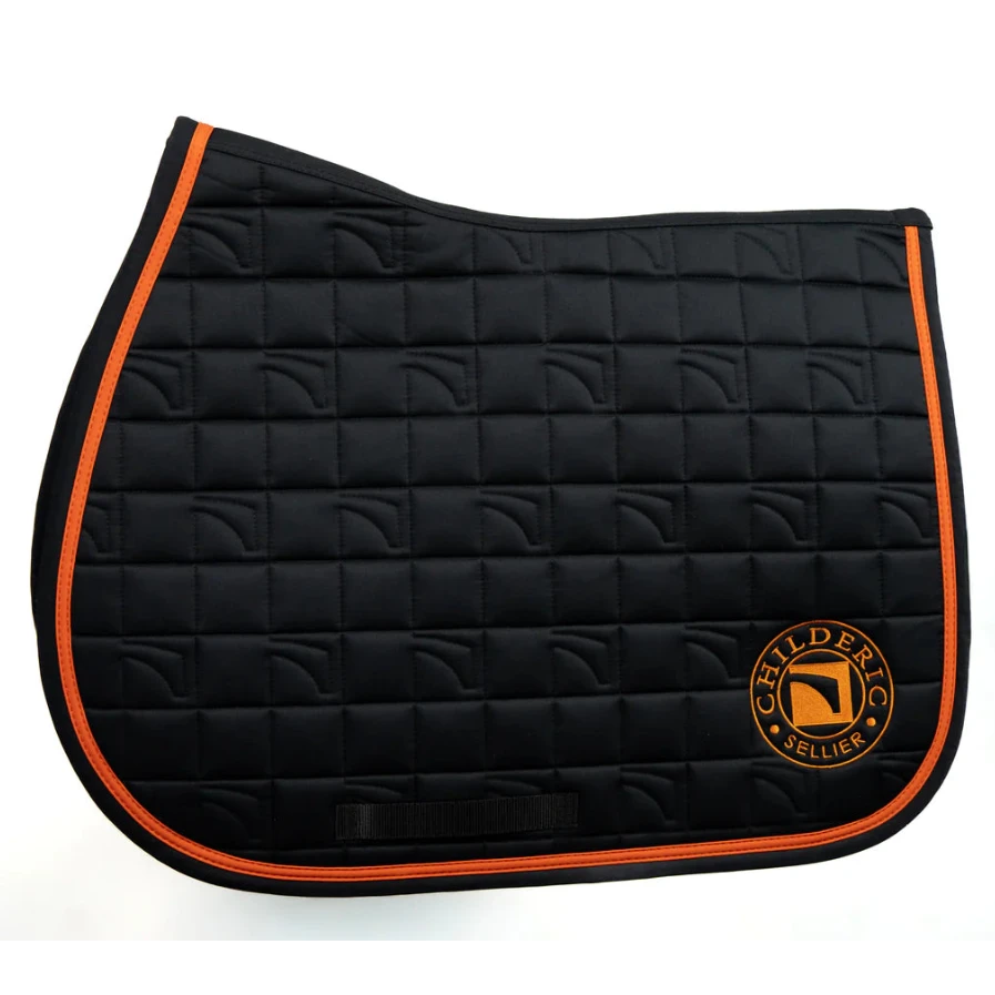 A Childeric black quilted equestrian saddle pad with vibrant orange piping and a circular embroidered Childeric logo on the lower right, set against a plain white background.